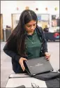  ??  ?? Cross Keys sophomore Ashanti Garcia packs up her Chromebook. The district has distribute­d more than 20,000 devices to middle and high school students.