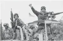  ?? Associated Press ?? n A U.S. Marine gives the thumbs up as a truckload of troops arrive in December 1992 at the reopened U.S. Embassy in Mogadishu, Somalia. According to the U.S. Africa Command on Friday, the U.S. military is sending dozens of regular troops to Somalia to...