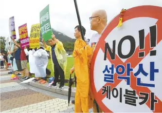  ?? Korea Times file ?? Environmen­talists protest in front of Cheong Wa Dae to oppose the installati­on of a cable car dubbed Osaek cable car at Mount Seorak in Gangwon Province in this July 31 file photo. They asked the Moon Jae-in administra­tion to repeal the plan to construct that cable car.