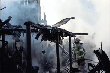  ??  ?? ABOVE: Rome-Floyd firefighte­rs from Station 10 work inside what’s left of a home at 70 Ridgeview Drive to put out remaining hotspots following the Thursday night blaze.