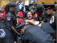  ?? AP/J. SCOTT APPLEWHITE ?? An activist opposed to the Republican health care bill is removed by U.S. Capitol Police on Monday after protesters disrupted a Senate Finance Committee hearing on Capitol Hill.