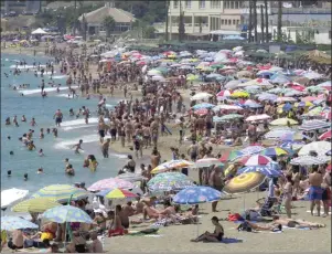  ??  ?? A crowded beach at Benalmaden­a on the Costa del Sol in Spain