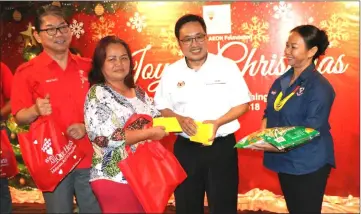  ??  ?? Chong (second right) gives away Christmas goodies, as Kenji (left) and Jimas look on.