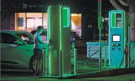  ?? Frederic J. Brown AFP/Getty Images ?? A MAN plugs his electric vehicle into a Monterey Park charging station. A Biden administra­tion plan will provide up to $7,500 in tax credits on 22 EV models.