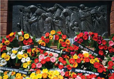  ??  ?? WREATHS ARE seen next to a sculpture during a ceremony marking Holocaust Remembranc­e Day at Warsaw Ghetto Square at Yad Vashem.