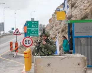  ?? (Yonatan Sindel/Flash90) ?? A SOLDIER GUARDS the entrance to Givat Assaf in 2018 after the attack.