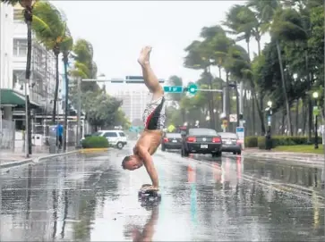  ?? Marcus Yam Los Angeles Times ?? ADAM TODD does a skateboard stunt on Ocean Drive, which is largely empty because Miami-Dade County directed more than 650,000 people to evacuate Miami Beach and other communitie­s ahead of Hurricane Irma.