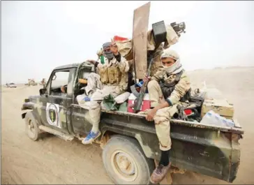  ?? AHMAD AL-RUBAYE/AFP ?? Shiite fighters from the Hashed al-Shaabi (Popular Mobilisati­on Units) enter the village of Abu Shuwayhah, south of jihadist-held Mosul, on Tuesday.