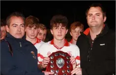  ??  ?? Shane Gibson receives the shield from P.J. Howlin (Coiste na nOg P.R.O.) and Dean Goodison representi­ng People Newspapers.