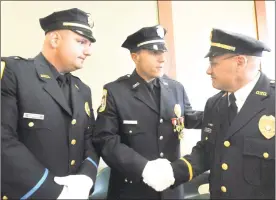  ?? Michael Duffy / Hearst Connecticu­t Media file photo ?? Above, Lt. Christian Carroccio, left, Detective Len LaBonia and Lt. Mark Williams, right, are all promoted during a ceremony at the Danbury Police Department in 2011. Right, Sgt. Rory DeRocco, with the Danbury Police traffic division, issues a ticket to a driver who went through a red light on North Street in Danbury in 2015.