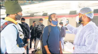  ?? ANSHUMAN POYREKAR ?? A BMC health worker collects a swab sample of a passenger for Covid-19 test, at Dadar Station in Mumbai, India, on Sunday