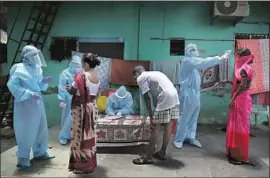  ??  ?? DOCTORS examine patients at a free medical camp in Dharavi. Health workers went door to door in April, quarantini­ng people who tested positive for the virus.