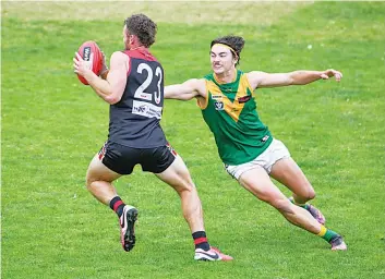  ?? Photograph­s by CRAIG JOHNSON. ?? Warragul’s James Davidson tries to evade the tackle by Leongatha’s Travis Nash.