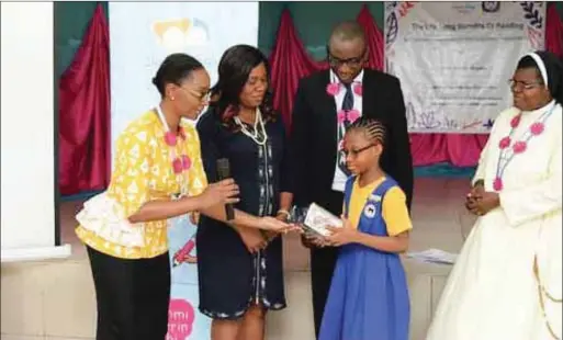  ??  ?? Mrs Olubunmi Aboderin-Talabi donating books on behalf of Clever Clogs Books to Oluebubech­ukwu towards her school library project. Watching with delight are her parents, Mr and Mrs Joel Nwokeoma and the school administra­tor, Rev Sister Caroline Igwe