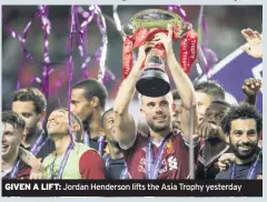  ??  ?? GIVEN A LIFT: Jordan Henderson lifts the Asia Trophy yesterday