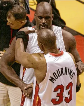  ?? ELIOT J. SCHECHTER / GETTY IMAGES ?? Shaquille O’Neal and Alonzo Mourning congratula­te each other after a Heat win over Detroit in the 2005 playoffs.