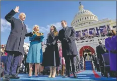  ?? (AP/Andrew Harnik) ?? Joe Biden is sworn in as the 46th president of the United States by Chief Justice John Roberts as Jill Biden holds the Bible during the inaugurati­on at the U.S. Capitol in Washington on Jan. 20 as their children Ashley and Hunter watch.