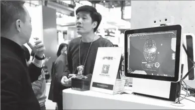  ?? ZHU XINGXIN / CHINA DAILY ?? Visitors try online payment through facial-recognitio­n technology at the Ant Financial Services Group booth at an internet expo in Wuzhen, Zhejiang province.