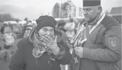  ?? VADIM GHIRDA/AP ?? A military priest tries to comfort a woman who was evacuated from Irpin at a triage point in Kyiv, Ukraine, on Wednesday.