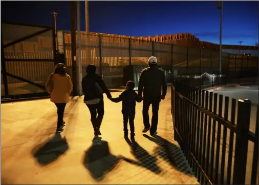  ?? MARIO TAMA — GETTY IMAGES ?? People walk on the U. S. side of the U. S.- Mexico border barrier on January 25, 2019 in San Diego.