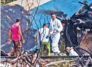  ??  ?? Investigad­ores forenses revisan los restos de un Boeing 737 que cayó en un campo de yuca en La Habana, Cuba.