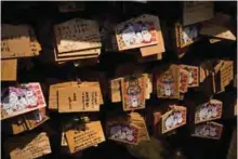  ??  ?? Photo shows wooden votive tables called “ema” with wishes and images of cats on them at the Gotokuji temple in Tokyo.