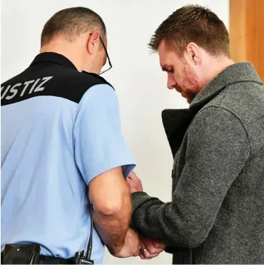  ?? Foto: dpa/Bernd Settnik ?? Dem Angeklagte­n Maik Schneider werden im Gerichtssa­al die Handschell­en abgenommen.