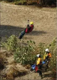  ?? STAN LIM — LOS ANGELES DAILY NEWS VIA AP ?? A man is hoisted out with the help of a San Bernardino County Sheriff’s helicopter on Tuesday in the Santa Ana River and near the borders of Rialto, Colton, and Riverside Three people and a dog were rescued by a helicopter after large amounts of rain...