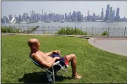  ?? AP Photo/Seth Wenig) ?? Hot spring days: In this Tuesday, May 15, 2018 file photo, Rick Stewart sits in the sunshine with the New York City skyline in the background, in a park in Weehawken, N.J. According to weather records released on Wednesday, June 6, 2018, May reached a...