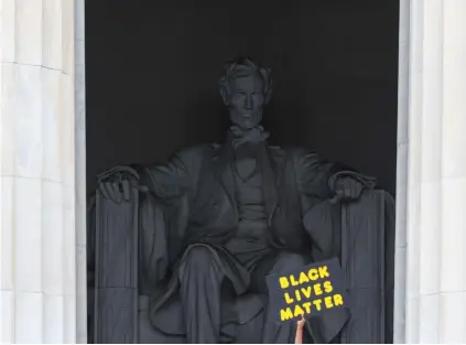  ?? (Tom Brenner/Reuters) ?? HOLDING UP a Black Lives Matter sign in front of the Lincoln Memorial in Washington, 2020.