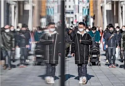  ??  ?? People walk past a subway station entrance in the Ginza shopping district of Tokyo yesterday as the city and its neighborin­g regions face surge of new COVID-19 cases. — AFP