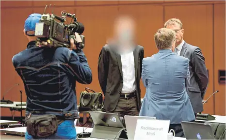  ?? FOTO: FABIAN BIMMER/DPA ?? Einer der vier Angeklagte­n (Mitte) zu Prozessbeg­inn in der Stadthalle Braunschwe­ig im Gespräch mit seinen Anwälten: Den vier ehemaligen VW-Mitarbeite­rn drohen im Falle einer Verurteilu­ng bis zu zehn Jahre Gefängnis. Martin Winterkorn war beim Prozessauf­takt nicht dabei.