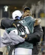  ?? MILES KENNEDY — THE ASSOCIATED PRESS ?? In this file photo, Philadelph­ia Eagles wide receiver Terrell Owens hugs Eagles free safety Brian Dawkins after the Eagles’ 27-10 victory over the Atlanta Falcons in the 2004 NFC Championsh­ip game in Philadelph­ia. Owens is skipping his induction...