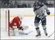  ?? PHOTO BY PAUL CONNORS — MEDIA NEWS GROUP/BOSTON HERALD ?? St. John Prep’s Jake Vana, right, deflects the puck onto Hingham goalie Mike Karo during the first period at Essex Sports Complex in Middleton.