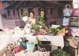  ??  ?? Wong (on left) with volunteer Laura Chella and the bags woven by the Penan women.