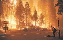  ?? Marcio Jose Sanchez / Associated Press ?? Cal Fire crew member Gabe Huck watches on Highway 168 as the Creek Fire burns in Shaver Lake (Fresno County).