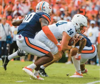  ?? BUTCH DILL/AP ?? Penn State quarterbac­k Sean Clifford carries the ball in for a touchdown as Auburn safety Zion Puckett defends during the first half of Saturday at Auburn.