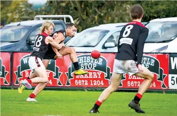  ?? ?? It’s youth versus experience as senior Warragul debutant Lucas Carter attempts to put Wonthaggi playing coach Jarryd Blair off balance as the latter snaps at goal.