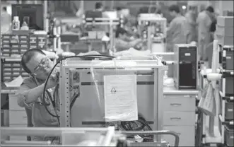  ?? BLOOMBERG ?? Employees at the General Electric Co healthcare unit’s production facility work to assemble medical X-ray devices in Beijing.