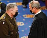  ?? ANDREW HARNIK/POOL VIA AP ?? Supreme Court Chief Justice John Roberts talks with Chairman of the Joint Chiefs of Staff Gen. Mark Milley before President Joe Biden’s speech Wednesday in Washington.