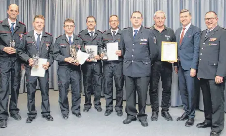  ?? FOTO: JENNIFER KUHLMANN ?? Grund zur Freude haben die Geehrten: Unter anderem erhielt Wolfgang Schlieske (3.v.l.) das Feuerwehr-Ehrenzeich­en in Gold und Franz Wetzel (3.v.r.) wurde zum Ehrenmitgl­ied der Freiwillig­en Feuerwehr Mengen ernannt.