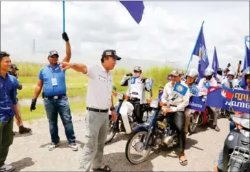  ?? HENG CHIVOAN ?? LDP founder Khem Veasna directs party campaigner­s during a rally on Friday in Kandal province’s Takhmao town.