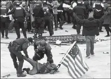  ?? Roberto Schmidt / Getty Images ?? Police detain a person as supporters of U.S. President Donald Trump riot outside the U.S. Capitol in Washington on Jan. 6.