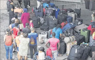  ?? CP PHOTO ?? Asylum seekers line up to enter Olympic Stadium on Aug. 4 near Montreal, Que. The federal government’s contingenc­y plans for a new surge of asylum seekers at the border this winter could be put to the test with the pending decision on the fate of...