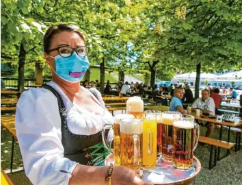  ??  ?? Bayerns Biergärten durften bereits am vergangene­n Montag wieder öffnen, an diesem Montag folgt die Innengastr­onomie. Hier wie dort müssen die Bedienunge­n Mundschutz tragen.