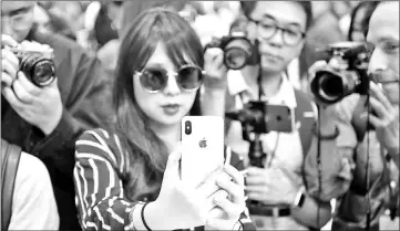  ??  ?? Taking photos as a woman tests out a new iPhone X during a media event at Apple’s new headquarte­rs in Cupertino in September. — AFP file photo