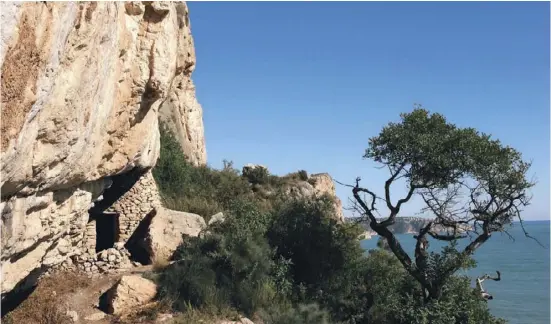  ??  ?? Der Eingang der Cova del Ti Domingo L’Abiar wurde mit einer Steinmauer verkleiner­t, um die Bewohner vor dem Wetter zu schützen.