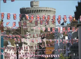  ?? Frank Augstein / Associated Press ?? Union Jack flags fly across the main shopping street in Windsor on Tuesday. Preparatio­ns are being made in the town ahead of the wedding of Britain's Prince Harry and Meghan Markle that will take place in Windsor on Saturday.