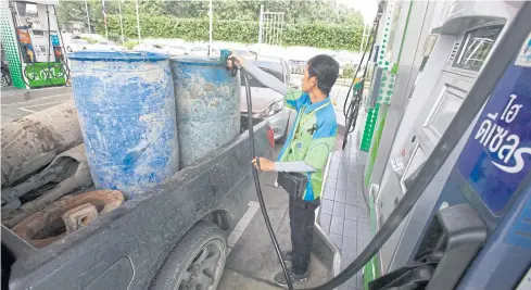  ?? APICHIT JINAKUL ?? A man refills a pickup truck at a petrol station in Bangkok. Removal of fossil fuel subsidies can bring economic, social and environmen­tal benefits in the long run.