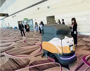  ??  ?? Hello mean machine!: Journalist­s watching an automatic robot cleaning at Changi Airport’s Terminal 4 in Singapore. — AFP